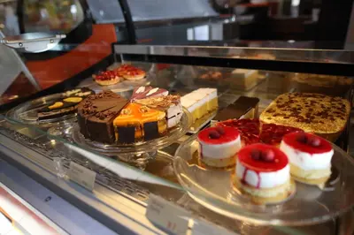 a display case with cakes and other desserts on plates at Hotel Pomaranča in Ptuj