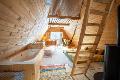 a tree house with a hammock and a tub at Bezgova Hišica in Bovec