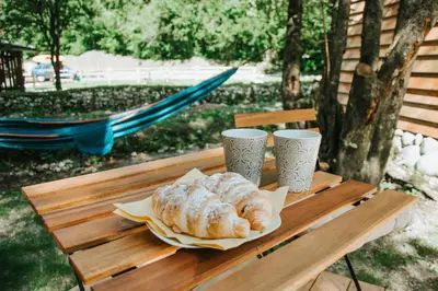 a table with two croissants and two cups on it at TOP rafting center in Bovec