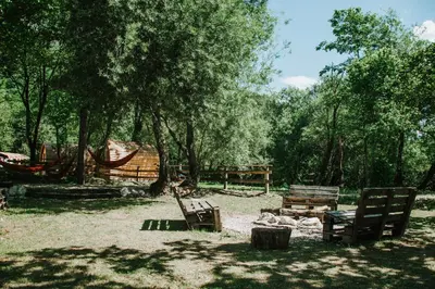 two wooden benches sitting in a field with trees at TOP rafting center in Bovec