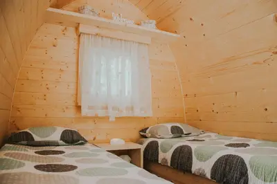 a bedroom with two beds in a wooden cabin at TOP rafting center in Bovec