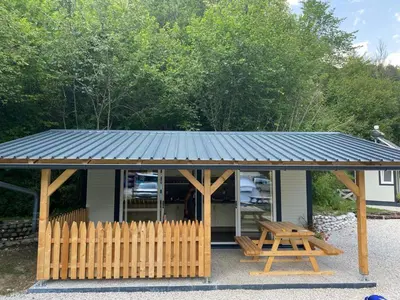 a pavilion with a wooden fence and a picnic table at TOP rafting center in Bovec