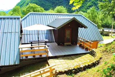 a small building with a table and an umbrella at TOP rafting center in Bovec