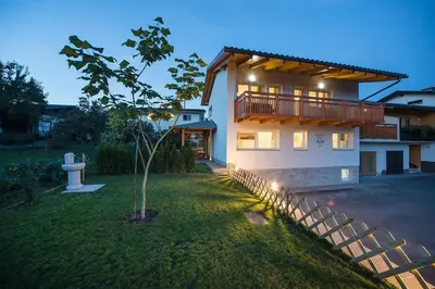 a house with a balcony and a yard at Apartment House Alp in Bled