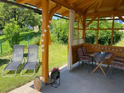 a gazebo with a table and chairs on a patio at Apartment House Alp in Bled