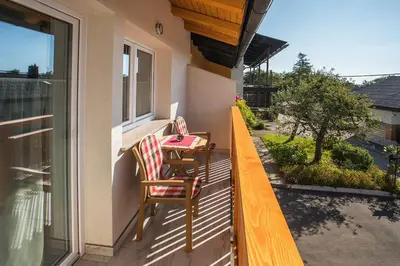 a porch with two chairs and a table on a balcony at Apartment House Alp in Bled