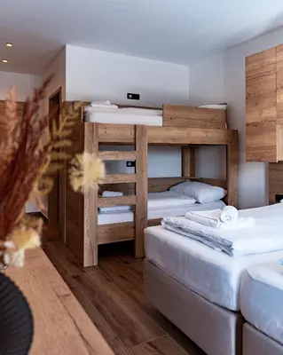 a room with two bunk beds and a couch at Grmovškov dom Kope in Mislinja