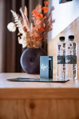 two bottles of water sitting on a wooden table at Grmovškov dom Kope in Mislinja