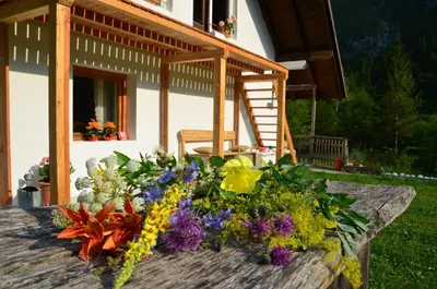 a bouquet of flowers on a table in front of a house at Bovec Home At Three Samoyeds in Soča