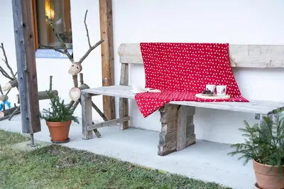 a wooden bench with a red napkin on it at Bovec Home At Three Samoyeds in Soča