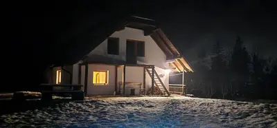 a house at night with a ladder in front of it at Bovec Home At Three Samoyeds in Soča