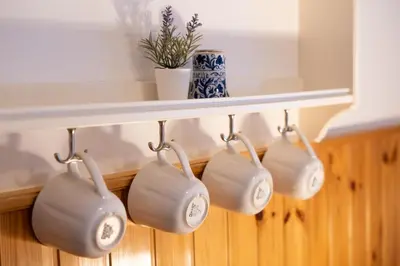 a rack with four white pots hanging from a wall at Bovec Home At Three Samoyeds in Soča