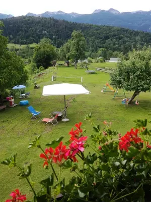 a field with a large white umbrella and chairs at Apartmaji Verica Ceklin in Bohinj