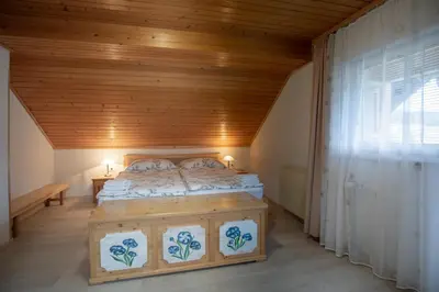 a bedroom with a bed with a wooden ceiling at Apartmaji Colja in Bohinj