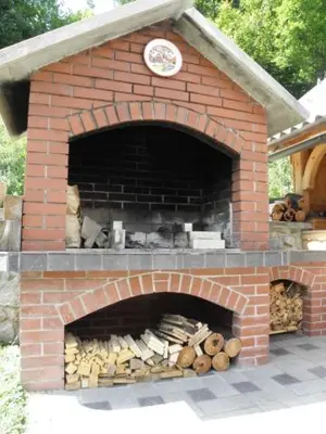 a brick oven with a bunch of logs in it at Apartmaji Colja in Bohinj