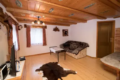 a living room with a couch and a tv at Turistična kmetija Gartner in Bohinj