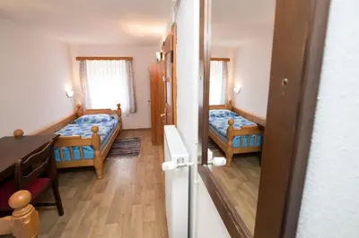 a small room with two beds and a table at Turistična kmetija Gartner in Bohinj
