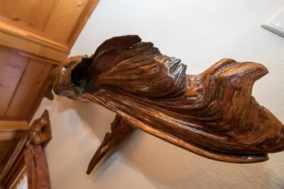a wooden bird sculpture hanging on a wall at Turistična kmetija Gartner in Bohinj