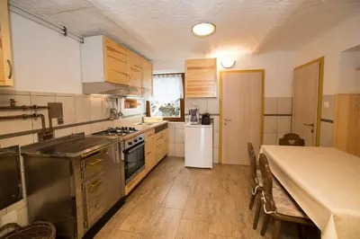 a kitchen with stainless steel appliances and a table at Turistična kmetija Gartner in Bohinj