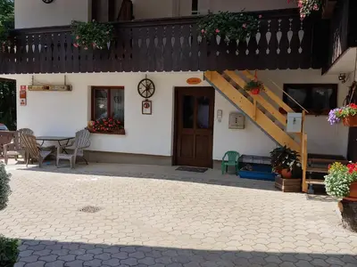a patio of a house with a table and a staircase at Turistična kmetija Pri Andreju in Bohinj