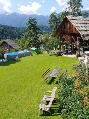two wooden benches sitting in a yard with a pavilion at Turistična kmetija Pri Andreju in Bohinj