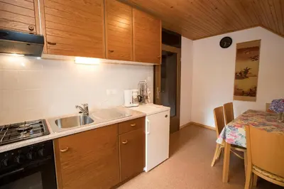 a small kitchen with a sink and a table at Turistična Kmetija Gartner 3a in Bohinj