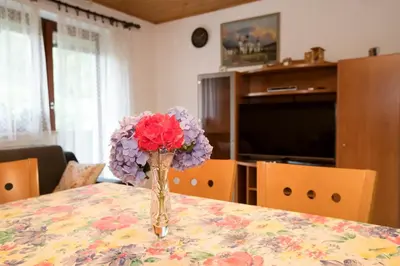 a vase filled with flowers sitting on a table at Turistična Kmetija Gartner 3a in Bohinj