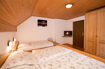 a bedroom with two beds and a wooden ceiling at Turistična Kmetija Gartner 3a in Bohinj