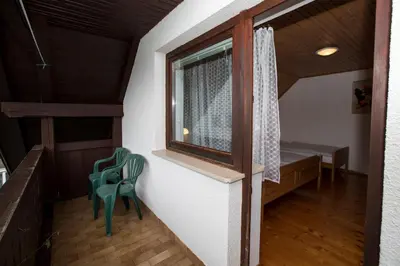 a room with two green chairs and a window at Turistična Kmetija Gartner 3a in Bohinj