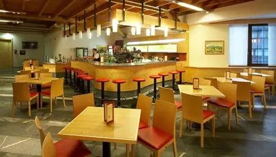 a restaurant with wooden tables and chairs and a bar at Depandansa Brinje in Zreče