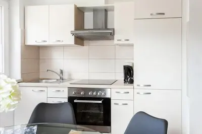 a kitchen with white cabinets and a stove top oven at Apartments Razingar 9 in Bled