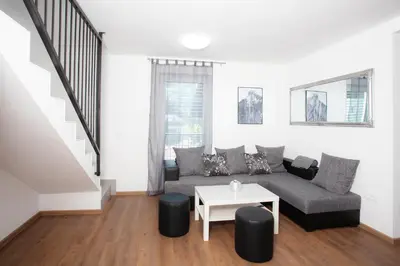 a living room with a couch and a table at Apartments Razingar 9 in Bled