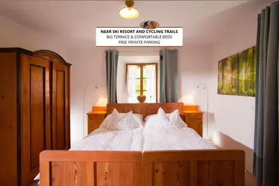 a bedroom with a wooden bed with white pillows at Juvanova hiša - Apartments and Rooms in Luče
