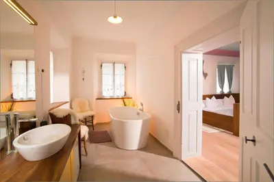 a bathroom with a large tub and a sink at Juvanova hiša - Apartments and Rooms in Luče