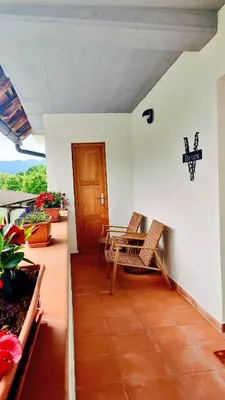 a patio with two chairs and a table on a house at Soča Home Bovec in Bovec
