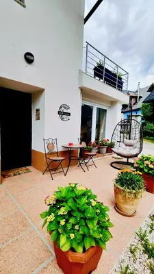 a patio with potted plants and a table and chairs at Soča Home Bovec in Bovec