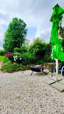 a green umbrella sitting next to a picnic table and a bench at Soča Home Bovec in Bovec