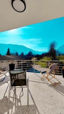 a patio with a table and a chair on a roof at Soča Home Bovec in Bovec