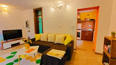 a living room with a couch and a tv at Soča Home Bovec in Bovec