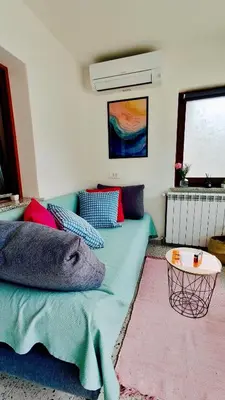 a living room with a couch with pillows and a table at Soča Home Bovec in Bovec