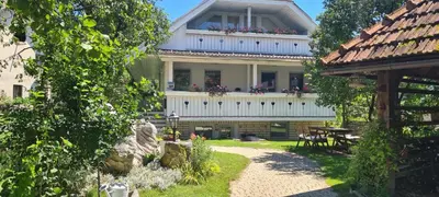 a large house with a balcony on top of it at Apartmaji Marinka Hodnik in Bohinj