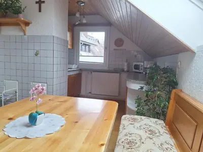 a kitchen with a wooden table with a vase of flowers on it at Apartmaji Marinka Hodnik in Bohinj