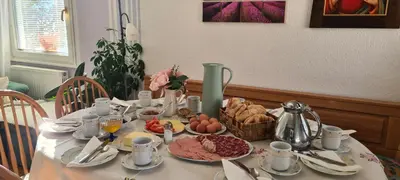 a table with a white table cloth with food on it at Apartmaji Marinka Hodnik in Bohinj