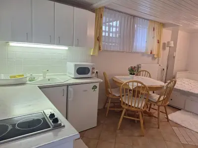 a kitchen with a table and chairs and a microwave at Apartmaji Marinka Hodnik in Bohinj