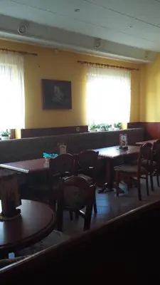 a dining room with tables and chairs and windows at Bed and Breakfast Kreft in Ljutomer