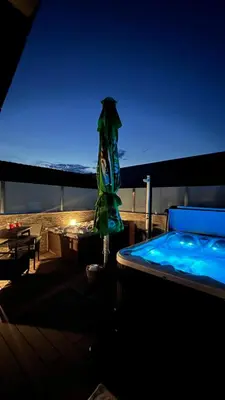 a swimming pool with an umbrella next to a hot tub at Bed and Breakfast Kreft in Ljutomer