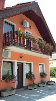 a building with a balcony with flowers on it at Bed and Breakfast Kreft in Ljutomer