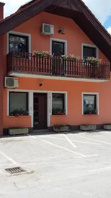 a building with a balcony with flowers on it at Bed and Breakfast Kreft in Ljutomer
