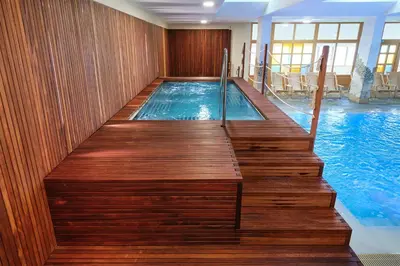 a swimming pool with a wooden stairway leading to a swimming pool at Bungalows Rogla in Zreče