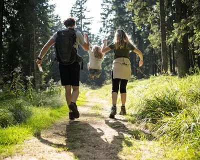 a couple and their child walking down a trail at Bungalows Rogla in Zreče